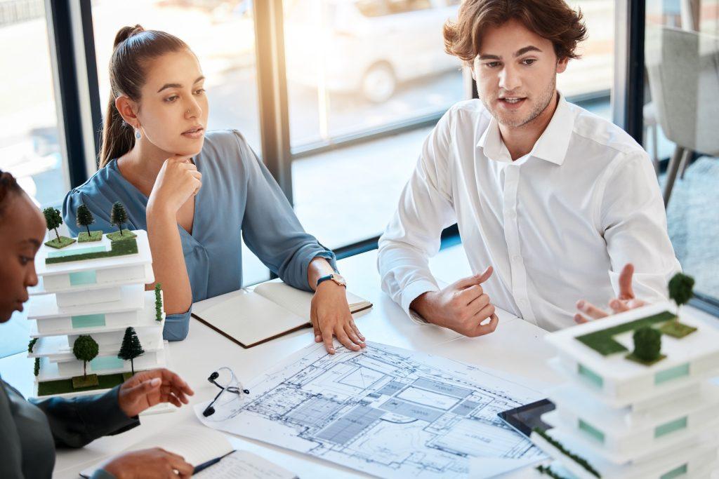 Team, architect engineer and planning building blueprint in meeting with logistics, diversity and t